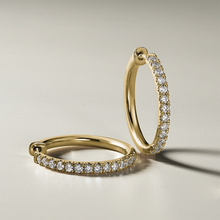 Load image into Gallery viewer, Stylish 18K yellow gold huggers, measuring 18mm in diameter and 2mm wide, featuring a solid strip of pavé diamonds totaling 0.42ct along the front, designed for comfort and reversible wear, handcrafted with love and attention to detail.
