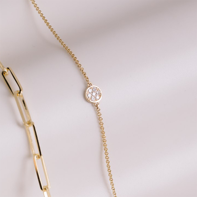 Charming bracelet in 18K yellow gold, adorned with seven twinkling diamonds totaling approximately 0.07tcw, capturing the essence of a full moon's glow and mystery, 7 inches in length with an adjustable station.