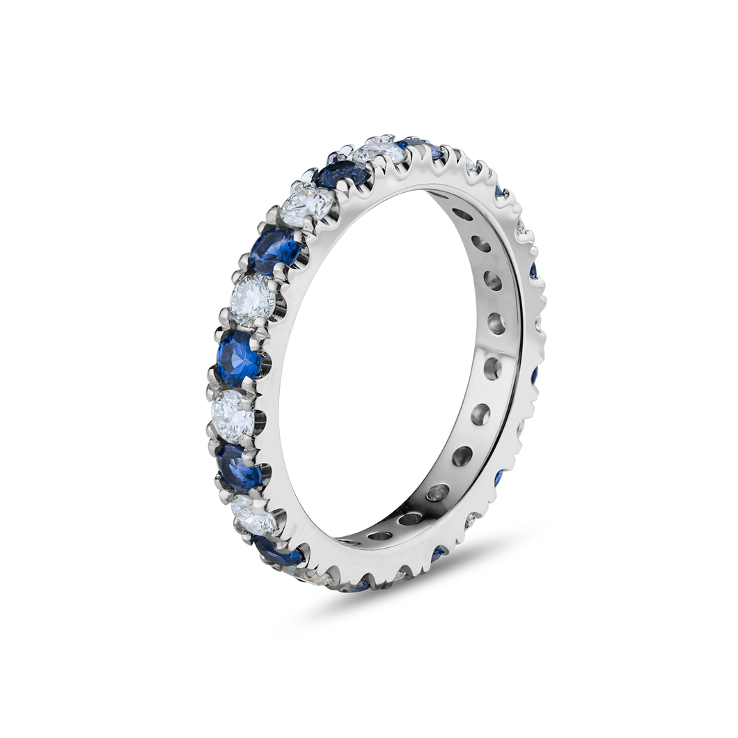 Full eternity ring in 18K white gold, beautifully set with round cut diamonds and sapphires, showcasing the vivid colors and brilliance of the gemstones, crafted with precision by Ex Aurum in Montreal.