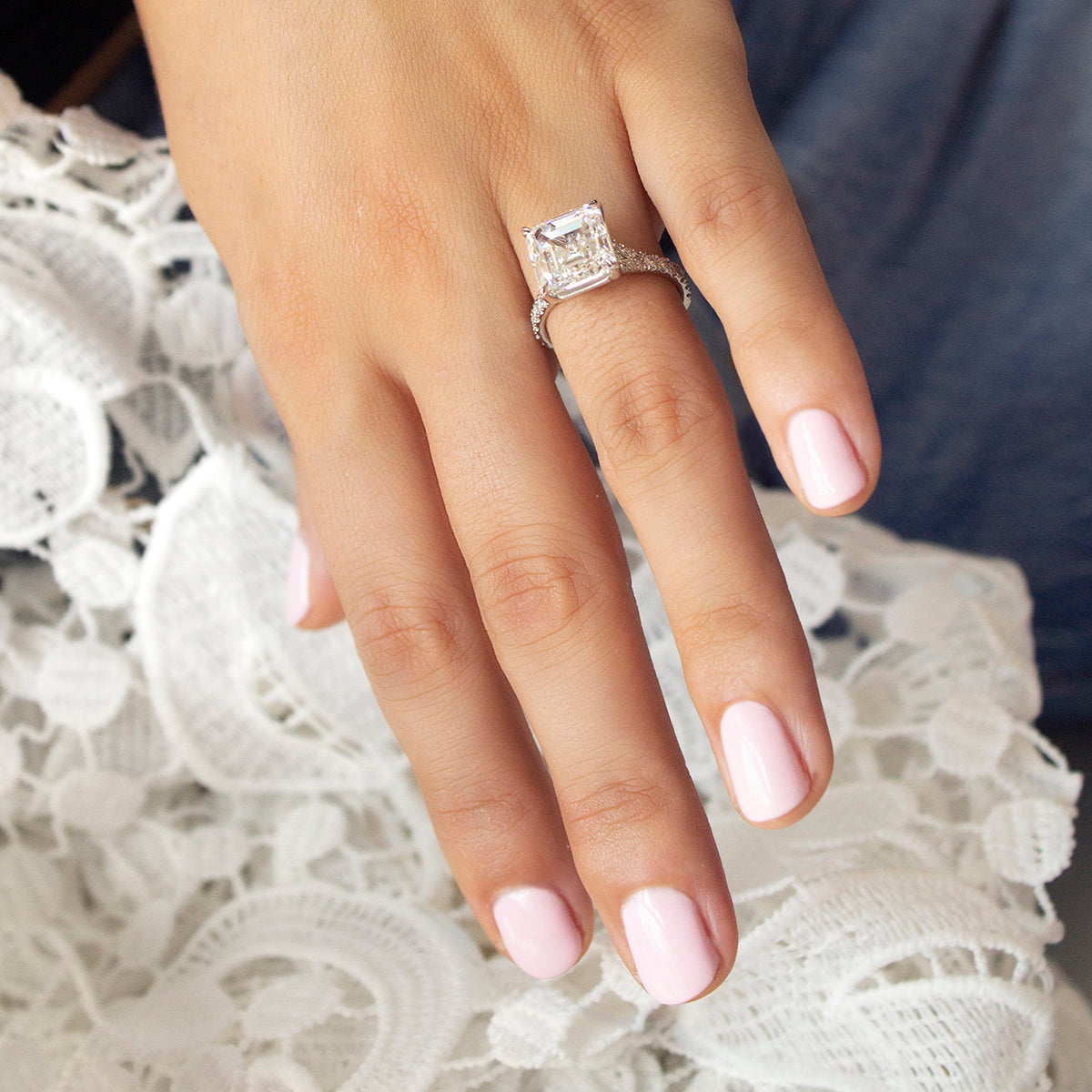 Exquisite platinum engagement ring featuring a 5ct Asscher cut lab diamond, VS1/F, in an eagle claw setting, with a split band and cathedral style silhouette, adorned with 0.39tcw of small round brilliant diamonds pavé set along the band, offering classic styling with Deco glamour.