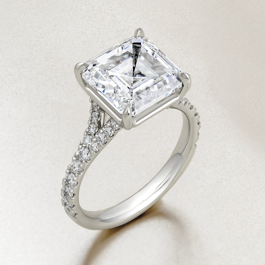 Exquisite platinum engagement ring featuring a 5ct Asscher cut lab diamond, VS1/F, in an eagle claw setting, with a split band and cathedral style silhouette, adorned with 0.39tcw of small round brilliant diamonds pavé set along the band, offering classic styling with Deco glamour.