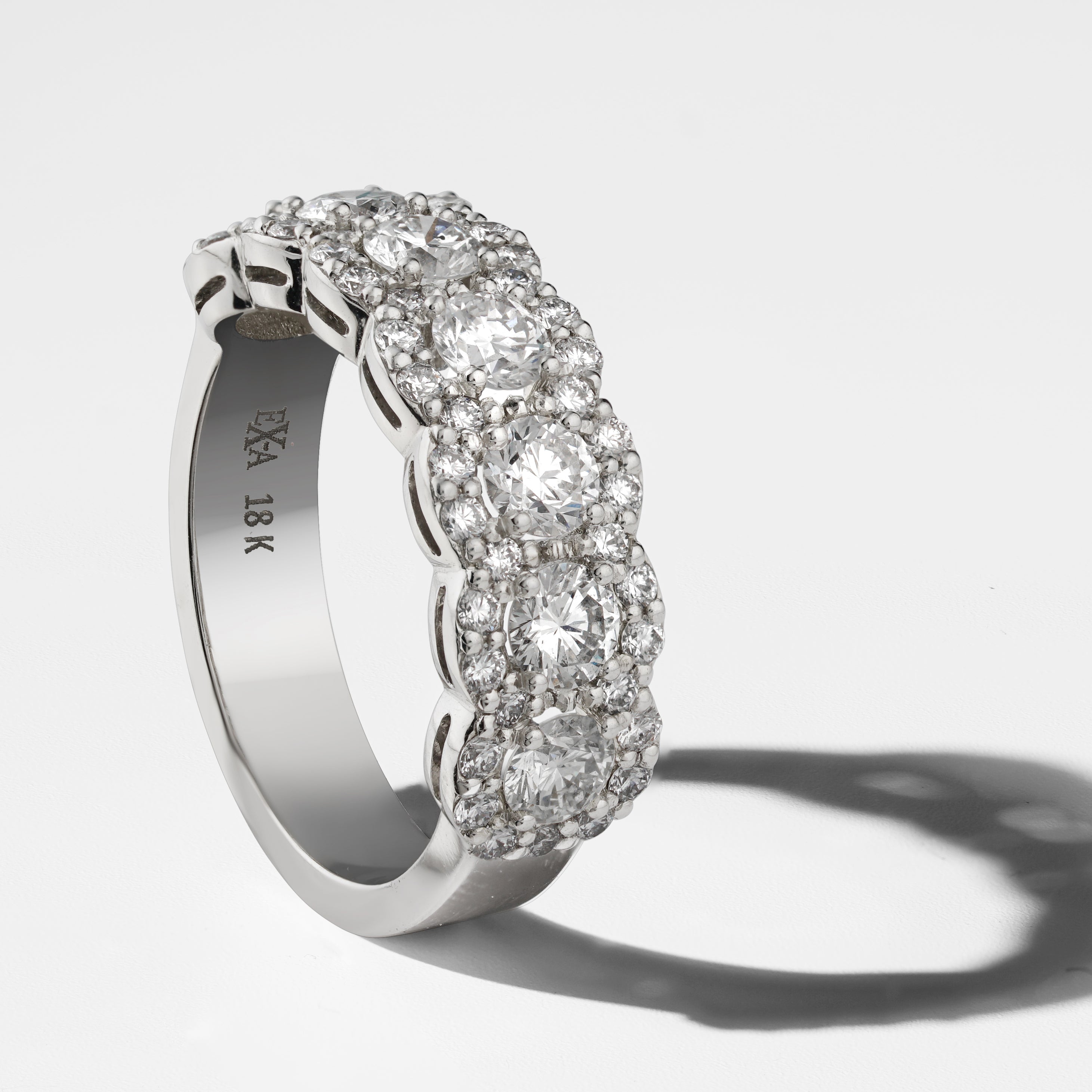 Exquisite ring in 18K white gold, handcrafted in Montreal by Ex Aurum, featuring seven feature diamonds surrounded by a continuous scalloped halo, with a total of approximately 53 diamonds and weighing about 5gr, showcasing a gleaming and elegant design.