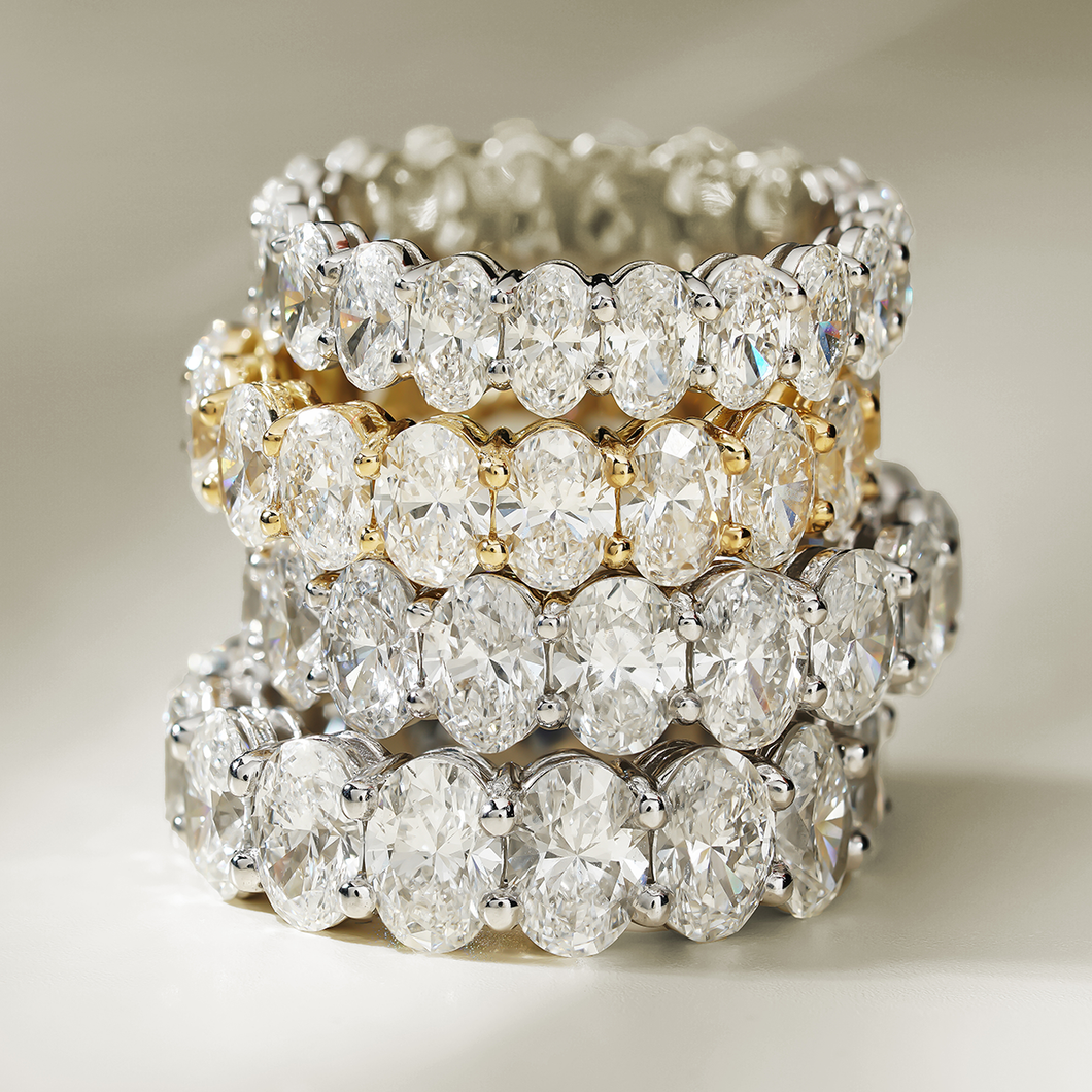 This 18K white gold full eternity band is a luxurious statement piece, featuring approximately 5.24tcw of oval lab-grown diamonds. The diamonds are set with two shared prongs, enhancing the band's sparkle from every angle.