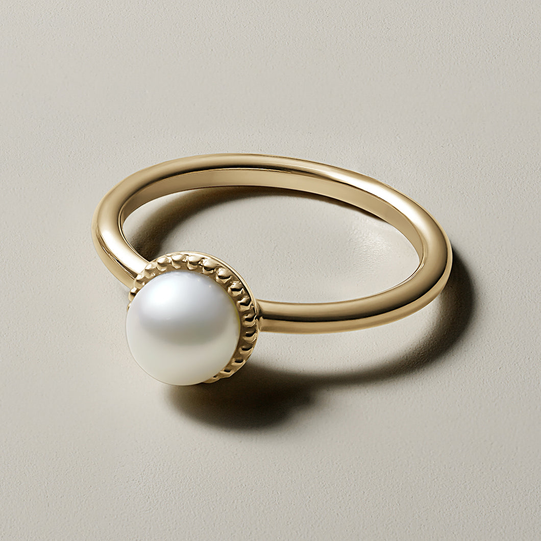 Elegant pearl promise ring in 14K yellow gold, featuring a 6-6.5mm round white pearl set in a textured milgrain frame, symbolizing tradition and history, handcrafted by Ex Aurum in Montreal.