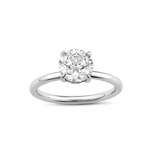 Elegant solitaire in 18K white gold, featuring a round brilliant laboratory diamond in an eagle claw setting, surrounded by a hidden halo of 16 small diamonds totaling 0.08tcw, blending classic and contemporary styles.