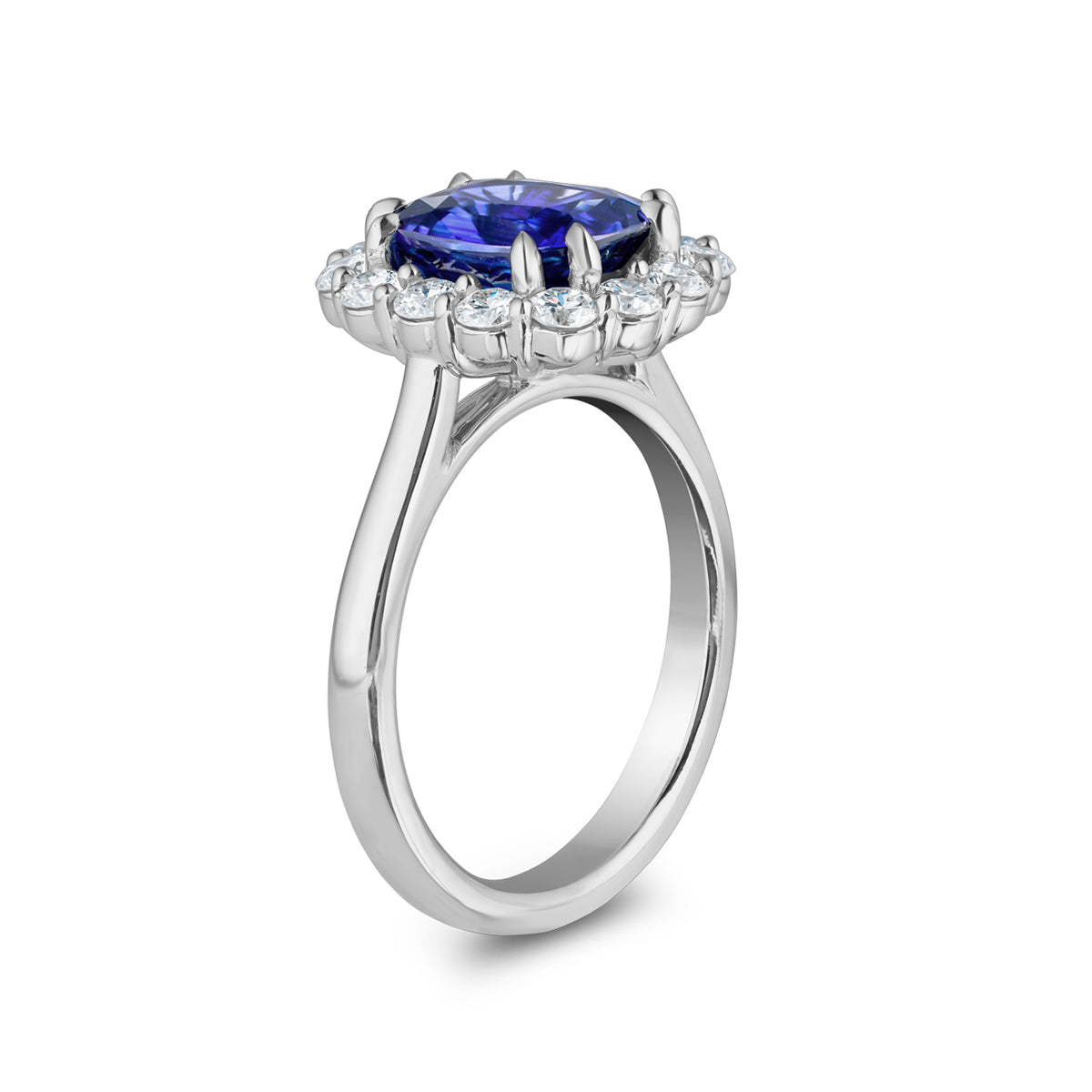 Stunning engagement ring in 18K white gold, featuring a vibrant cushion-cut Ceylon sapphire, surrounded by 14 round brilliant diamonds totaling 0.70tcw, with double eagle claw settings, handcrafted in Montreal by Exaurum.