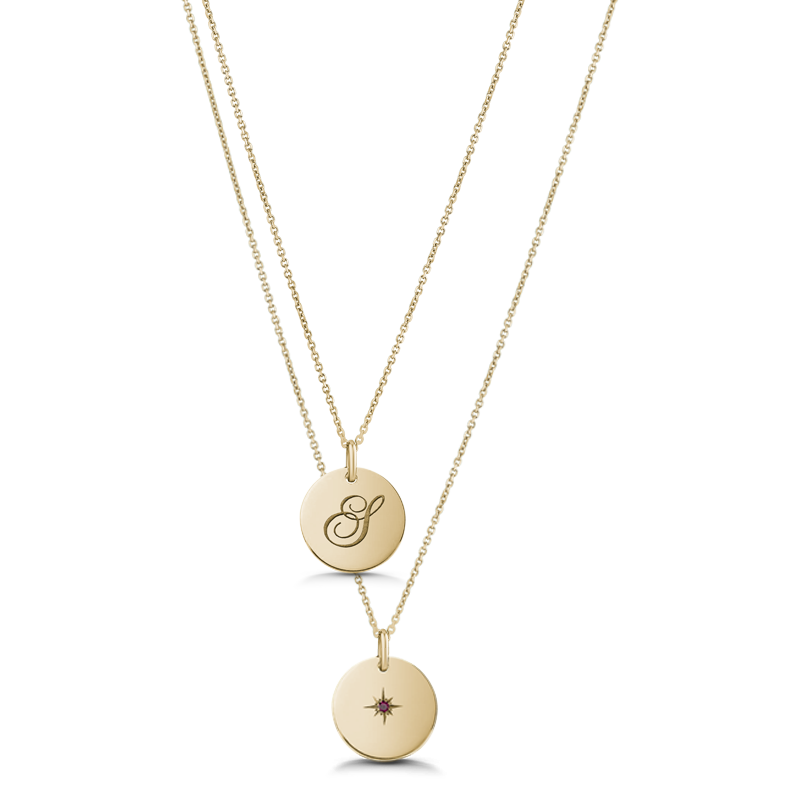 Unique double-sided 14K yellow gold pendant, featuring a script-styled initial on one side and a gemstone set in a diamond-cut star pattern on the reverse, measuring 15mm in diameter, accompanied by an 18" adjustable chain.