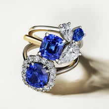 Charger l&#39;image dans la galerie, Stunning engagement ring in 18K white gold, featuring a vibrant cushion-cut Ceylon sapphire, surrounded by 14 round brilliant diamonds totaling 0.70tcw, with double eagle claw settings, handcrafted in Montreal by Exaurum.
