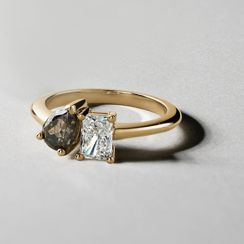 Unique engagement ring in 18K yellow gold, featuring a 0.72ct princess cut lab diamond and a 0.85ct pear-shaped salt & pepper diamond, embodying a blend of classic and unconventional beauty.
