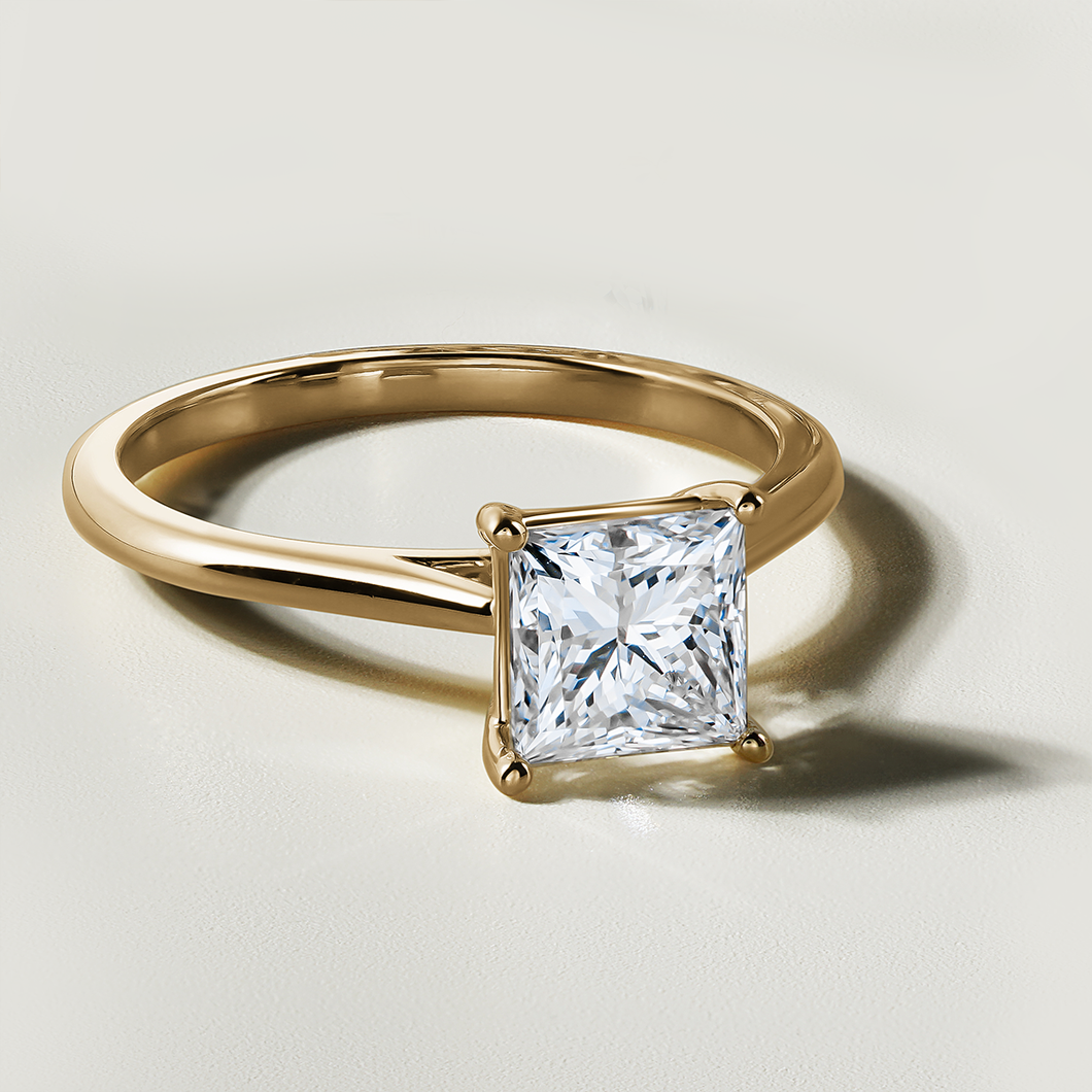 Stunning engagement ring in 18K yellow gold, featuring a 1.51ct princess cut laboratory diamond, SI1 G, set in a prong setting with cathedral shoulders, radiating brilliance and fire.