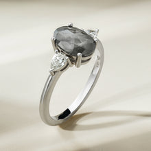 Charger l&#39;image dans la galerie,  This unique engagement ring combines traditional and modern elements, featuring a 1.59ct oval salt &amp; pepper diamond from the grey diamond family. It&#39;s accented by two pear-shaped diamonds totaling 0.32ct each, set in 18K white gold.
