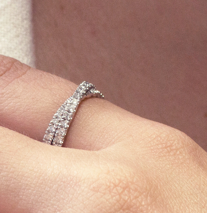 Unique band in platinum, weighing approximately 4.3gr, featuring an almost Mobius-twisting design with a crossover wrap adorned with 1.13tcw of round diamonds pavé set.