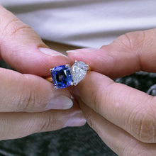 Load image into Gallery viewer, Exquisite ring in 18K white and yellow gold, featuring a 1ct pear-shaped lab diamond and a 2.81ct cushion-cut tanzanite, symbolizing unique and enduring beauty.
