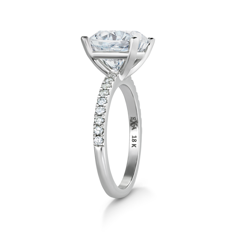 Exquisite engagement ring in 18K white gold, featuring a 3.18ct cushion cut diamond in a four-claw setting, complemented by 0.23tcw of small pavé set diamonds on the band, crafted to harmonize with various band styles.