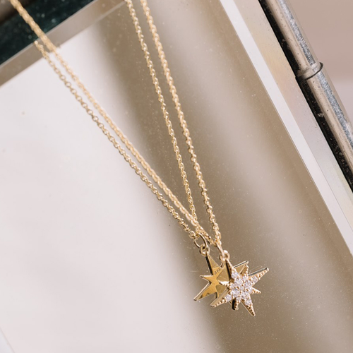 This 14K yellow gold pendant, handcrafted by Ex Aurum in Montreal, features a spiked shape adorned with 13 diamonds, totaling 0.18ct. It hangs on an 18