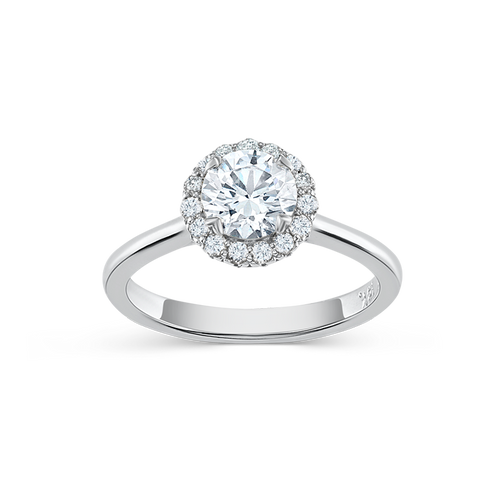 Elegant engagement ring in 18K white gold, featuring a 0.85ct round brilliant center diamond encircled by 0.19tcw smaller diamonds in a bead set halo, with a tulip-inspired decorative gallery and four fancy tipped prongs.