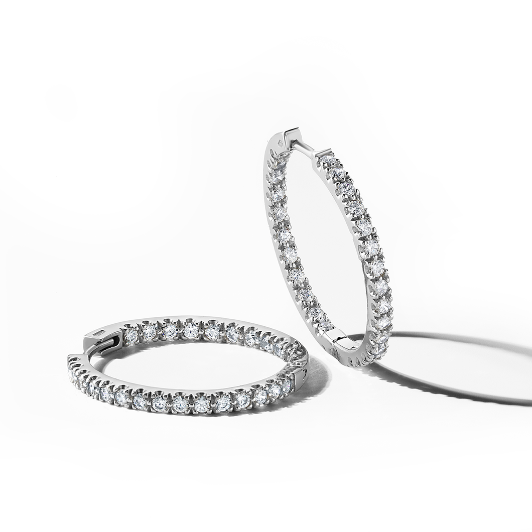 Hoops in 18K white gold, handcrafted by Ex Aurum in Montreal, featuring 52 round brilliant diamonds totaling approximately 1.82tcw, set both inside and out on 25mm hinged hoops for a captivating visual impact.
