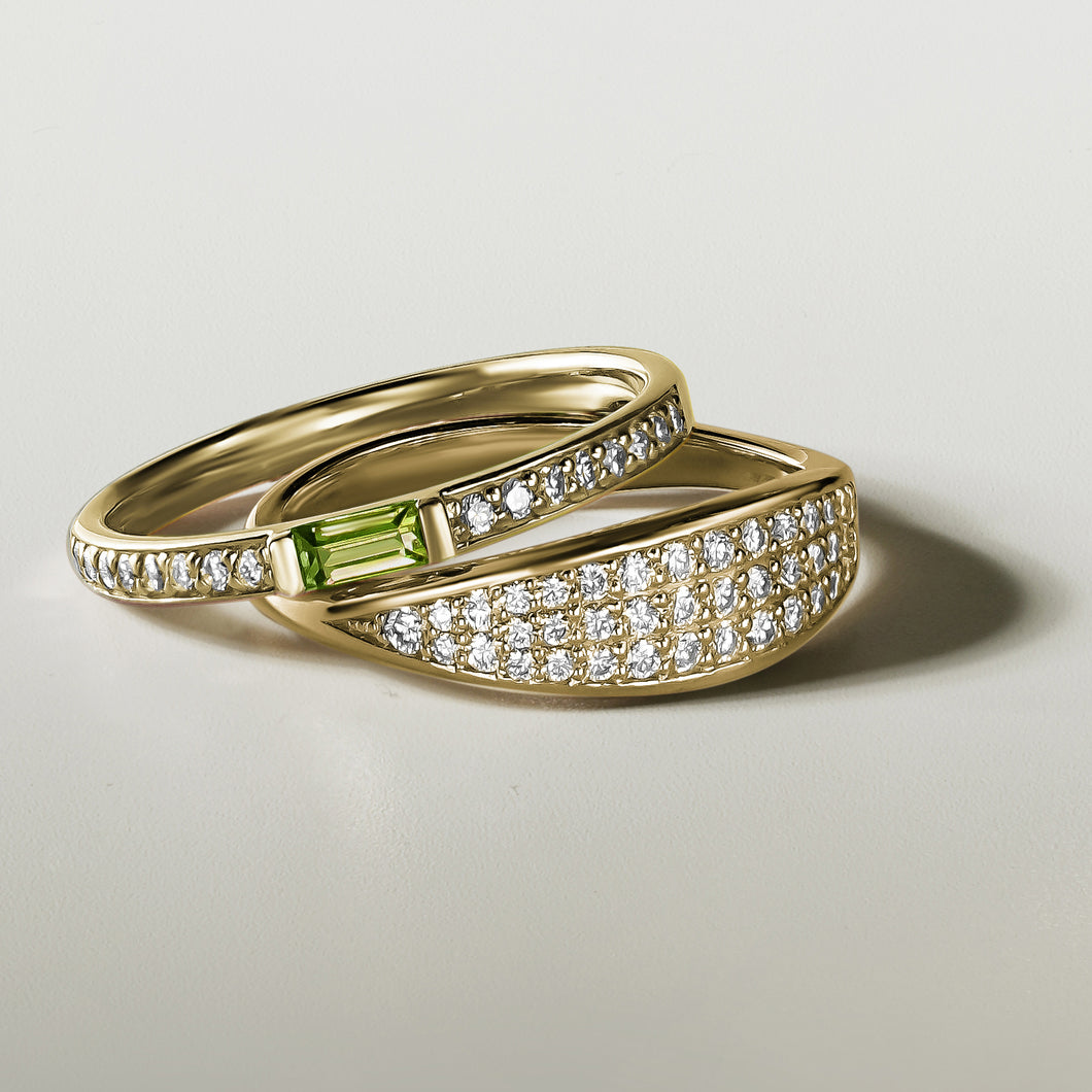 Elegant 14K yellow gold ring with a dynamic character, featuring a peridot baguette and 0.13ctw of diamonds in a combined pavé and bar setting.