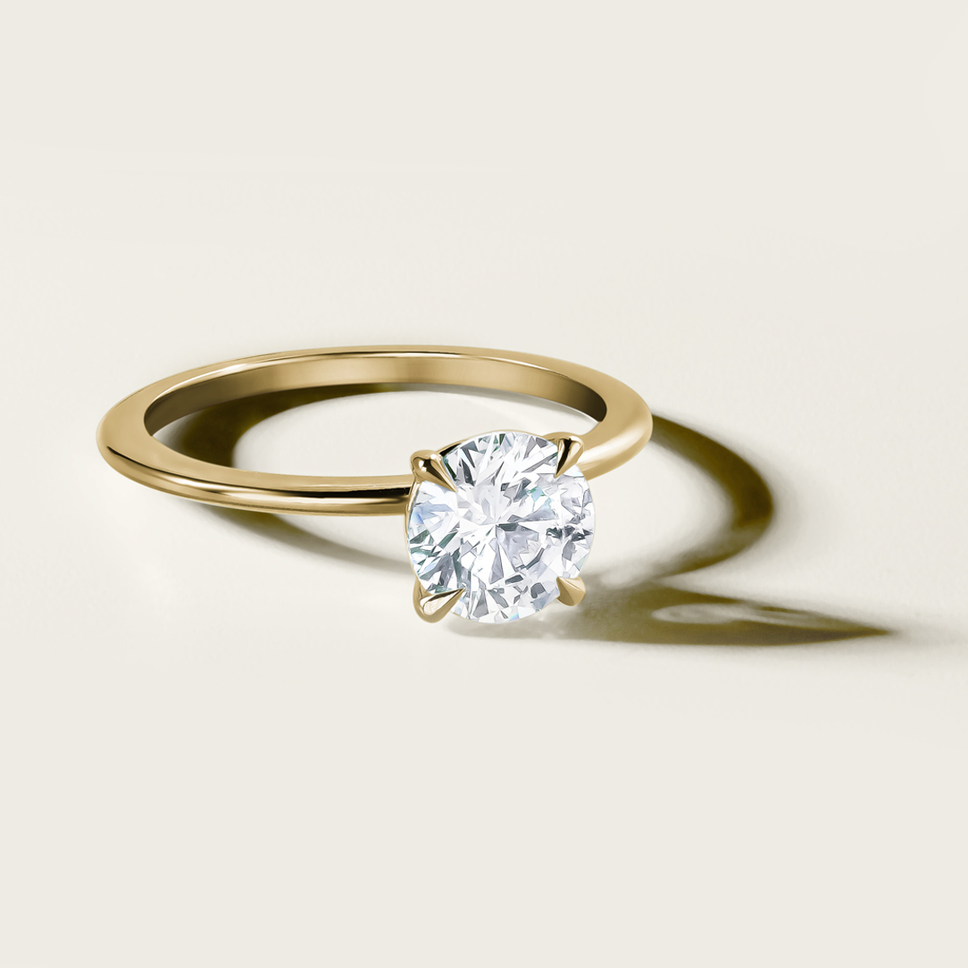 Delicate 'Fine Spirit' solitaire engagement ring in 14K yellow gold, featuring a 1.01ct lab diamond on a slim 1.6mm band with a reverse taper and finely pointed claws, embodying minimalist elegance.