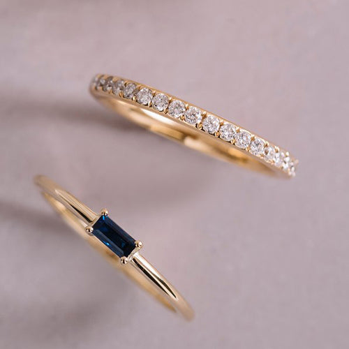 Elegant ring in 18K yellow gold, featuring a 0.15ct emerald-cut sapphire in a prong setting, set on a low and lean band.